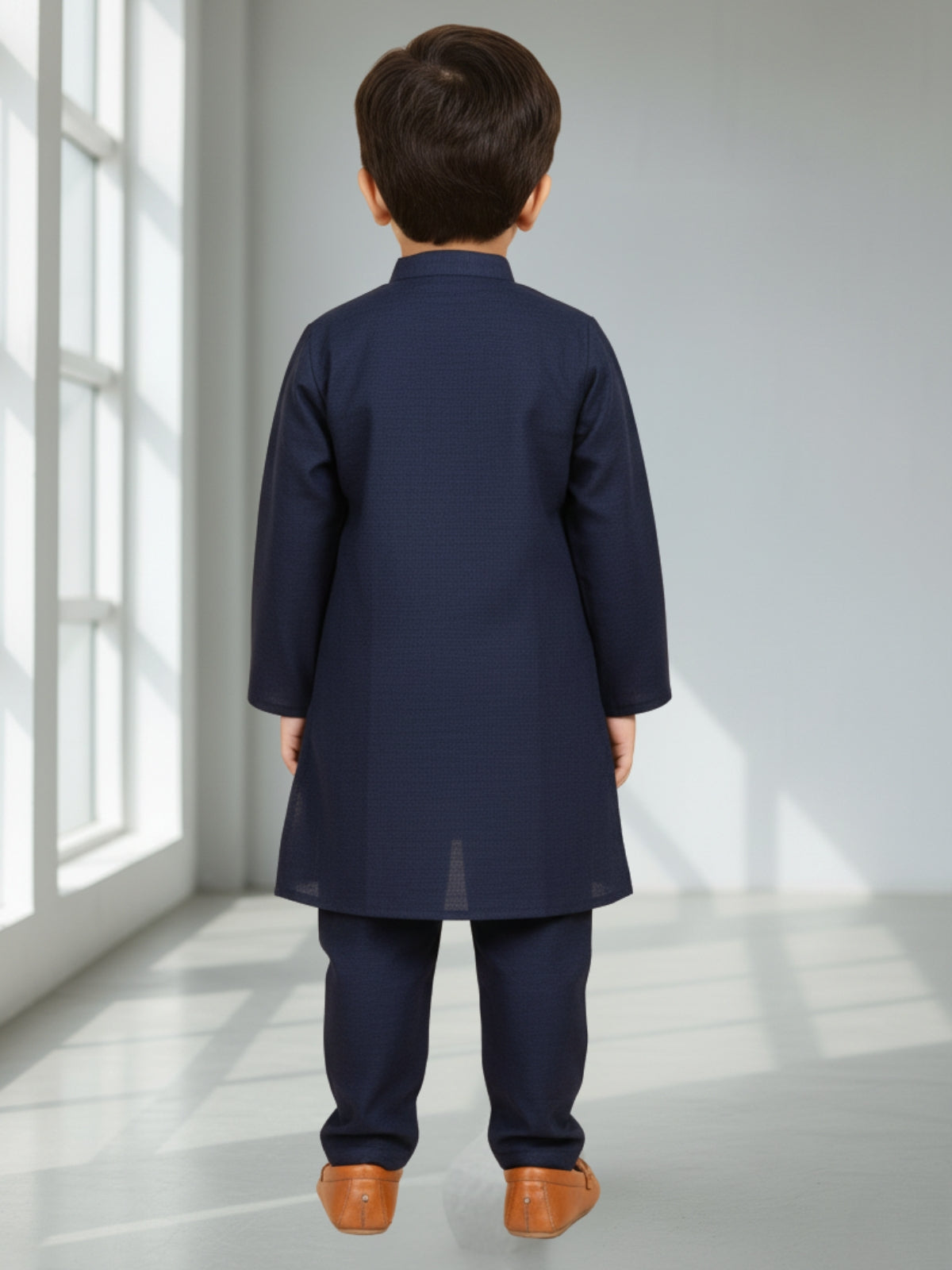 Child wearing a navy kurta with pants in a bright room